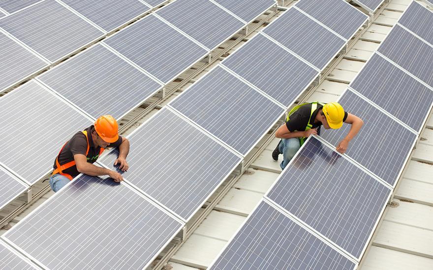Mężczyźni pracujący przy panelach słonecznych